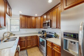 A kitchen with wooden cabinets, stainless steel appliances, a sink, and a window with blinds. - Beautifully remodeled dog-friendly Casita with shared heated pool & hot tub (Tucson)