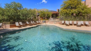 A clear swimming pool with lounge chairs and a wooden deck. - Snowbird-friendly condo w/shared heated outdoor pool, hot tub & tennis (Tucson)