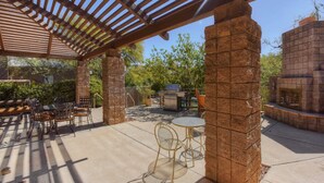 An outdoor patio with a pergola, stone pillars, and a barbecue area. - Snowbird-friendly condo w/shared heated outdoor pool, hot tub & tennis (Tucson)
