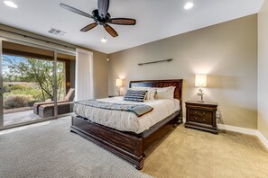 A bedroom with a large bed, a ceiling fan, a nightstand, and a view of the outdoors. - Golf-Course View Condo with Central AC & Washer/Dryer - Shared Pool & Hot Tub (Scottsdale)