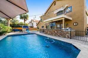 Una piscina con una parete in pietra e un balcone.