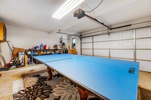 A pool table in a garage with a white door and a ceiling-mounted projector. - Dog-Friendly Gem near Golf Course W/ Private Pool, Fast WiFi & Central AC (Avondale)