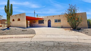 A building with a flat roof, arched windows, and a red awning. - Fun, Dog-Friendly Home w/ Game Room, Ping-Pong, Patio, Fast WiFi, & AC (Tucson)
