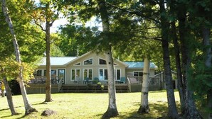 A two-story house with a porch and a covered deck. - Mapleview - Three Bedroom Cottage, Sleeps 12 (Cloyne)