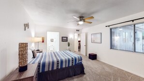 A bedroom with a bed, a ceiling fan, a window with blinds, and a door leading to another room. - Dog-Friendly Home near Downtown with Private Patio, Gas Grill, Central A/C, W/D (Sun City)