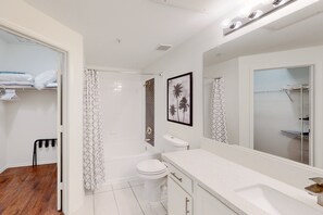 A modern bathroom with a bathtub, toilet, and sink.
