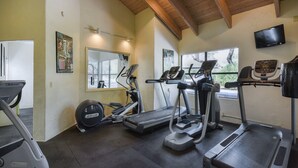 A gym with treadmills, elliptical machines, and a stationary bike.