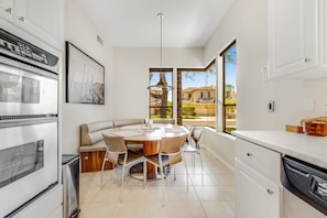 A modern kitchen with a dining area, large windows, and a view of the outside. - Dog-friendly monthly rental with private backyard, grill, W/D - great location (Scottsdale)