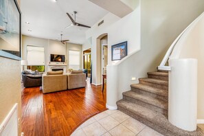 A modern living room with hardwood flooring, a fireplace, a sofa, and a television. - Dog-friendly monthly rental with private backyard, grill, W/D - great location (Scottsdale)