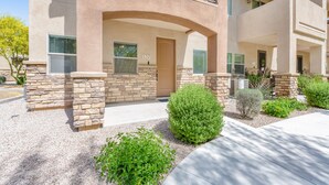 A multi-story building with a stucco exterior, stone accents, and a well-maintained front yard with shrubs and a gravel pathway. - Spacious townhouse with fast WiFi, central AC, washer/dryer, pool, & hot tub (Mesa)