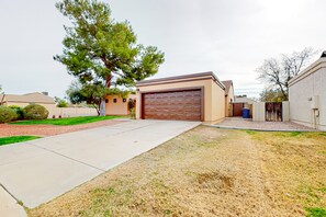 A residential driveway with a garage, a lawn, and a tree. - Sunny South Tempe gem with enclosed yard, covered lanai, grill, & washer/dryer (Tempe)