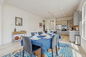 A modern dining area with a blue tablecloth, chairs, and a patterned rug. - Bright desert oasis  w/hot tub & grill - shared pool & tennis in  55+ community (Rancho Mirage)