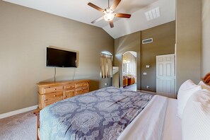 A bedroom with a bed, a ceiling fan, a TV, a dresser, and a mirror. - Spacious home surrounded by palms with pool, grill, children (Litchfield Park)