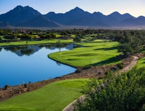 A golf course with a pond, trees, and mountains in the background. - Scottsdale Serenity: Your Stylish Desert Retreat with Stunning Views and Endless (Scottsdale)