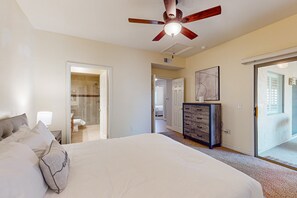 A bedroom with a large bed, a ceiling fan, a dresser, and a sliding glass door leading to a balcony. - Scottsdale Serenity: Your Stylish Desert Retreat with Stunning Views and Endless (Scottsdale)
