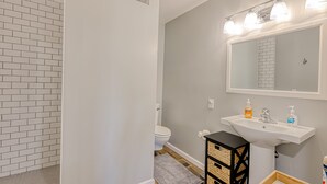 A bathroom with a white sink, a mirror, and a toilet. - Dog-friendly mountain-view home with private pool, outdoor lounging & W/D (Cave Creek)