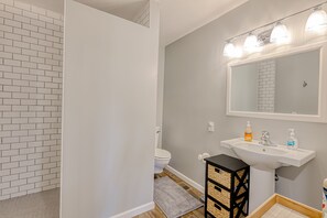A bathroom with a white sink, a mirror, and a toilet. - Dog-friendly mountain-view home with private pool, outdoor lounging & W/D (Cave Creek)