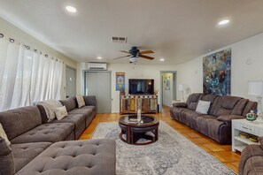 A living room with two sofas, a coffee table, and a ceiling fan.