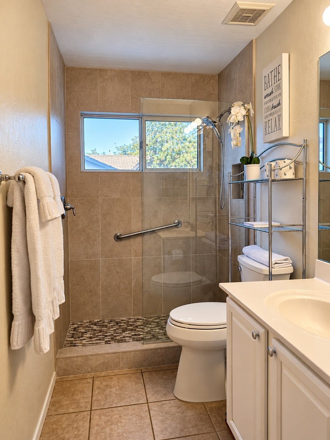 A bathroom with a shower, toilet, and a window providing a view of the outdoors.