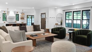 Un salon moderne avec un canapé, des fauteuils, une table basse et un tapis.