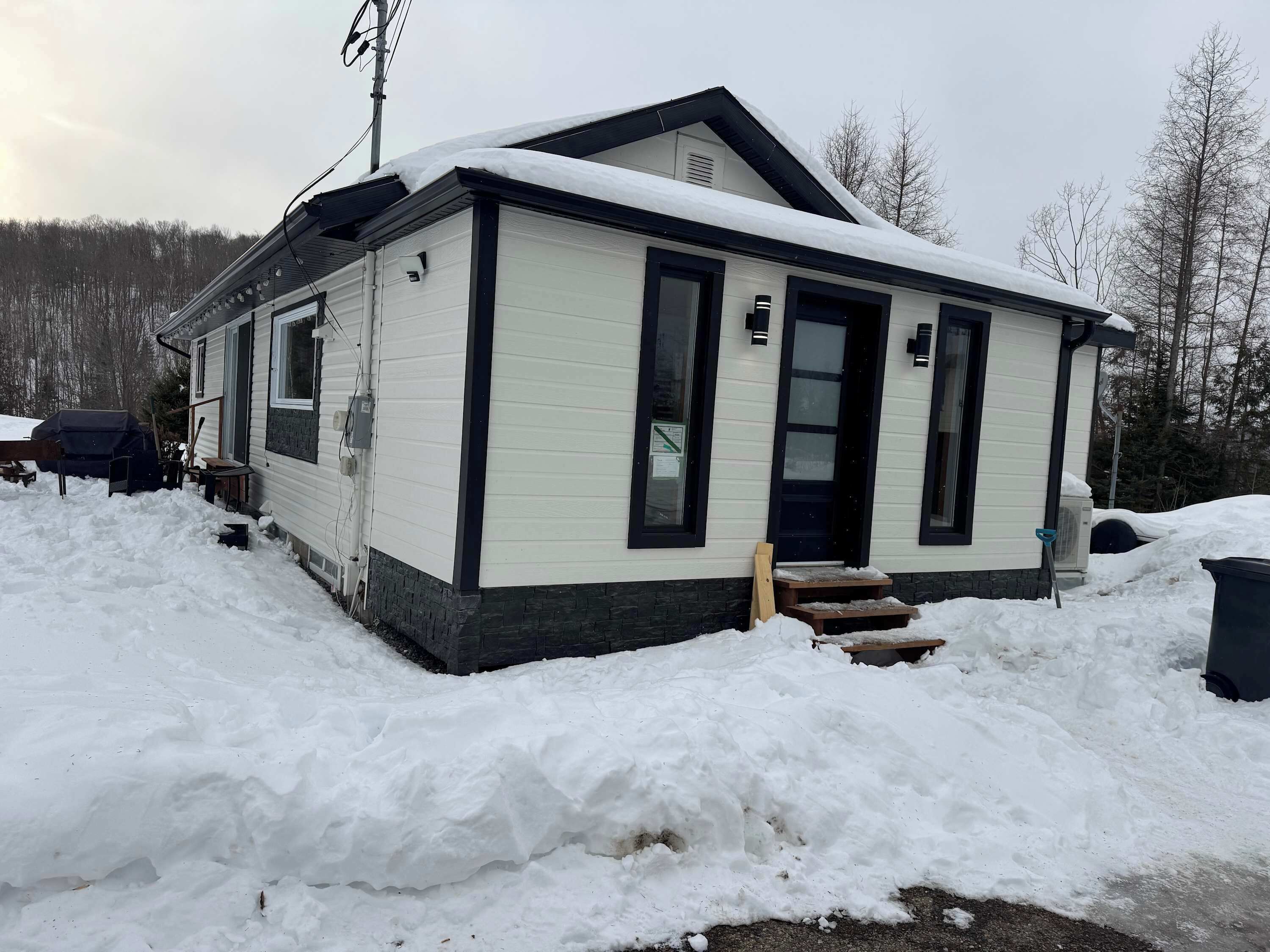 A single-story building with a snow-covered roof and a small porch.