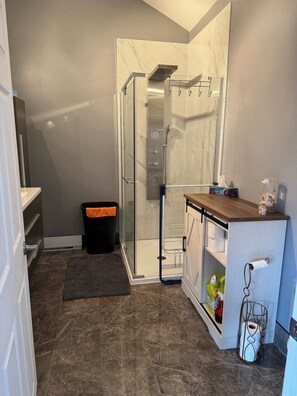 A bathroom with a shower, a toilet, and a sink.