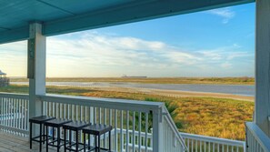 A covered porch with a view of a river and marshland. - La Sirena by Avantstay Communal Pool + Covered Lounge + Marsh Views + Near Port A Beach (Port Aransas)