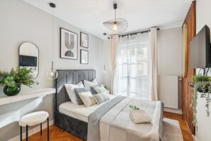 Une chambre à coucher moderne avec un lit, une table de chevet et un grand miroir.