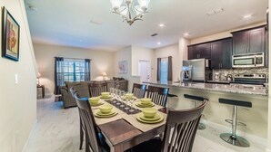 A modern kitchen with dark cabinets, stainless steel appliances, and a granite countertop. - Storey Lake Magic - Five Bedroom Villa, Sleeps 10 (Kissimmee)