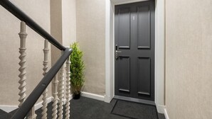 A staircase with a white balustrade leading to a dark grey door with a number '1' above it. - City Centre Apartment Sleeps 2 With Wifi (Edinburgh)