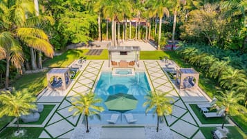 Una piscina al aire libre, sillones reclinables de piscina