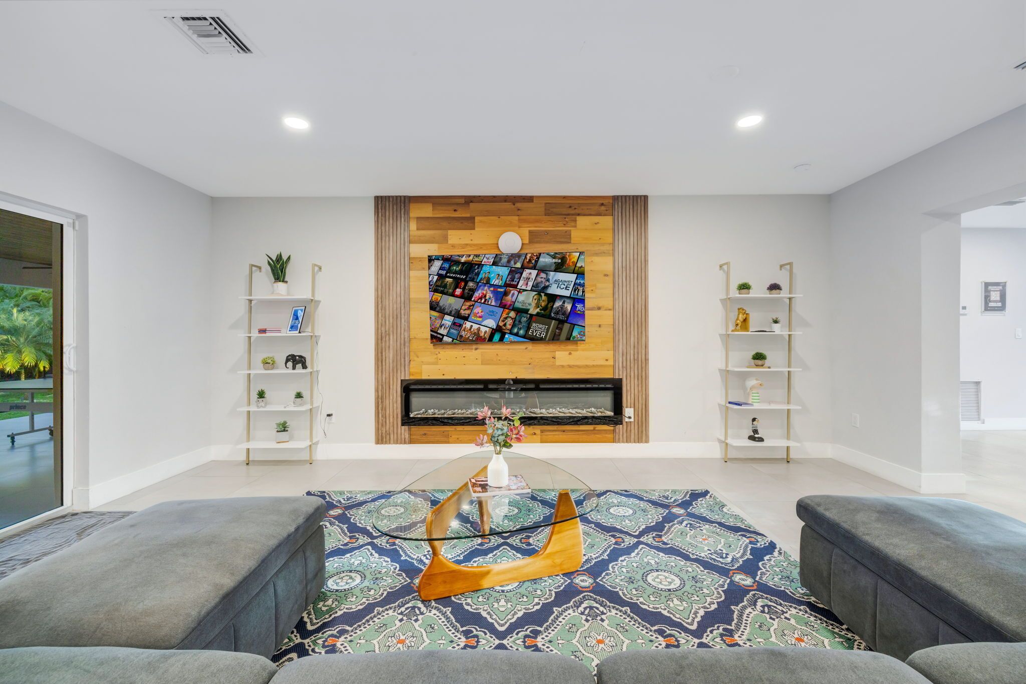 A modern living room with a fireplace, a coffee table, and two sofas.