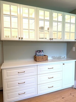 A white cabinet with multiple drawers and a glass-top shelf.