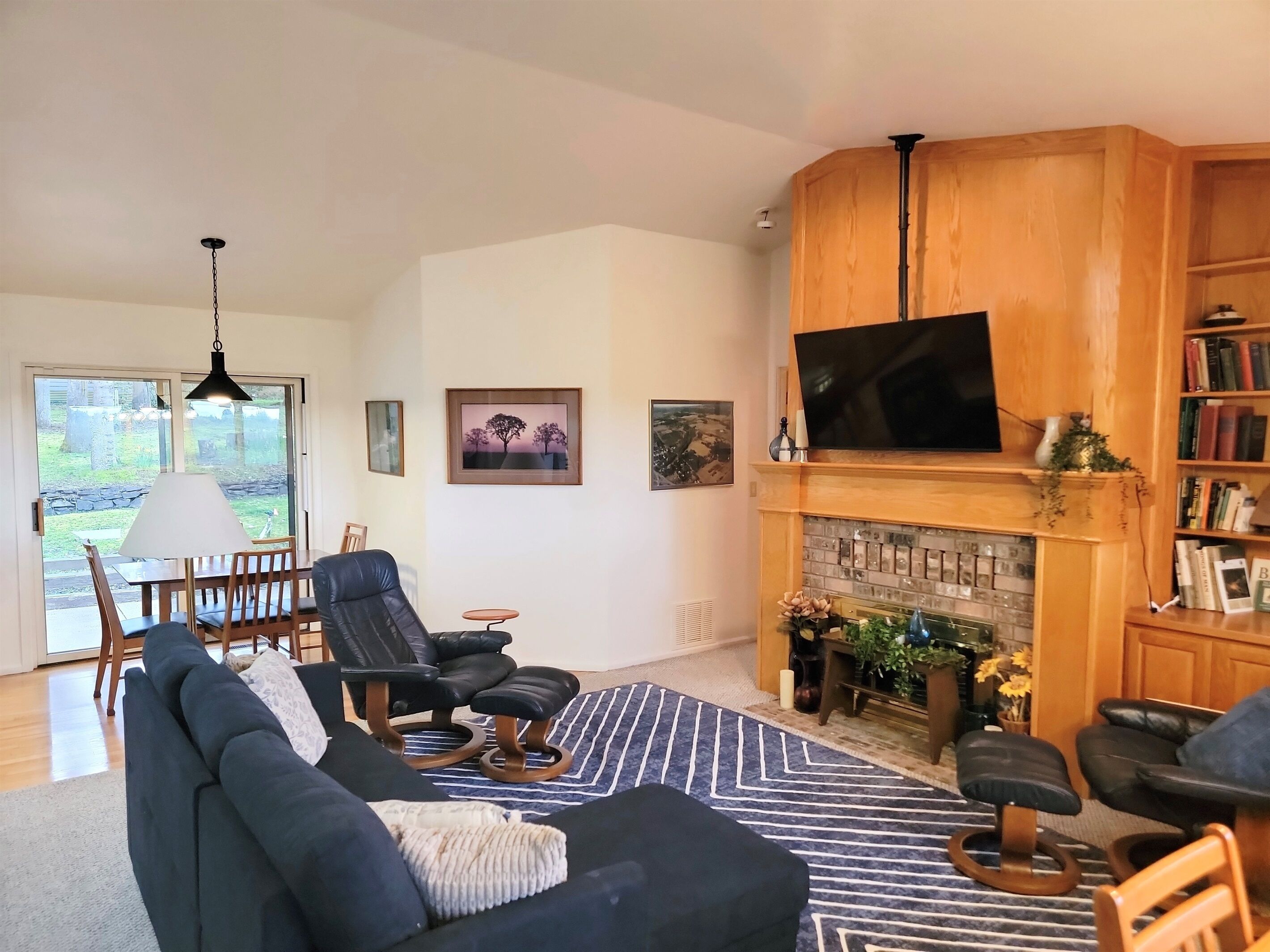 Een woonkamer met een open haard, een televisie en een boekenkast.