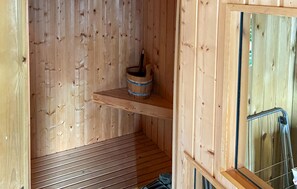 A wooden sauna with a bench, a bucket, and a window. - Gorgeous home in Odder with sauna (Odder)