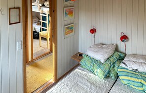 A bedroom with a bunk bed, a bedside table, a chair, and a window. - Gorgeous home in Odder with sauna (Odder)