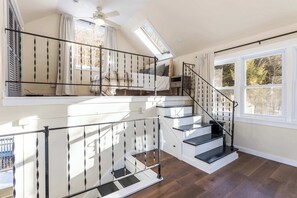 A multi-level staircase with a metal railing, a skylight, and a view of the outdoors.