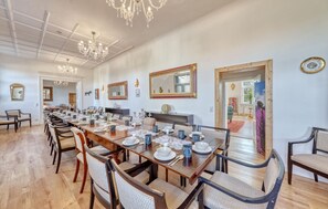 A dining area with a long wooden table set for a meal, surrounded by chairs. - Beautiful home in Kletzin with sauna (Kletzin)