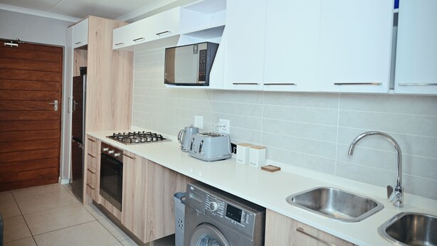 A modern kitchen with a built-in oven, microwave, and dishwasher.