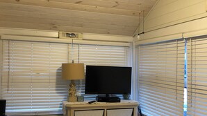Een kamer met een bed, een televisie op een dressoir, een plafondventilator en een bord met de tekst 'WELCOME'.