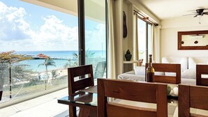 A balcony with a view of the sea, wooden furniture, a table, and a ceiling fan. - Grand Boréna Hotel Boutique (Playa del Carmen)