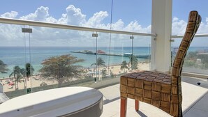 A balcony with a view of the beach, a chair, and a round table. - Grand Boréna Hotel Boutique (Playa del Carmen)