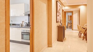 Une cuisine moderne avec des meubles blancs, un îlot central et un coin repas comprenant une table et des chaises.