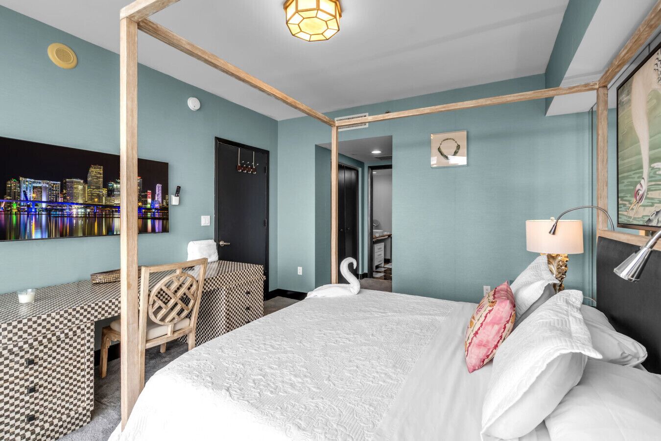 Een hotelkamer met een bed, een bureau, een stoel en uitzicht op een stadshorizon.