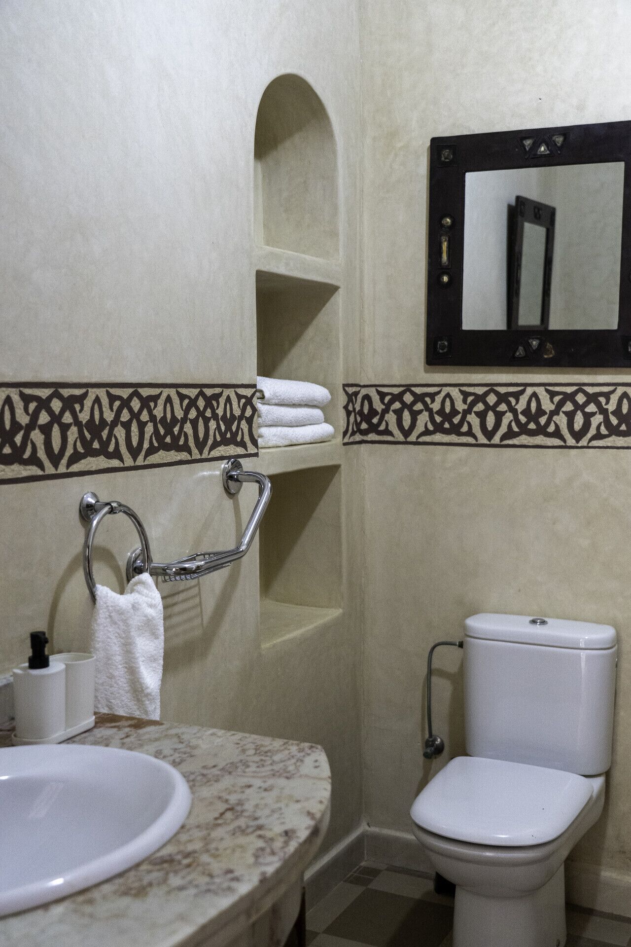 Ein Badezimmer mit Waschbecken, Toilette und Spiegel.