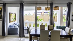 Un coin repas avec une table et des chaises, une vue sur l’extérieur et un tableau accroché au mur.