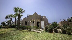 Un edifici amb un estil arquitectònic únic, amb portals arquejats i façana de pedra.