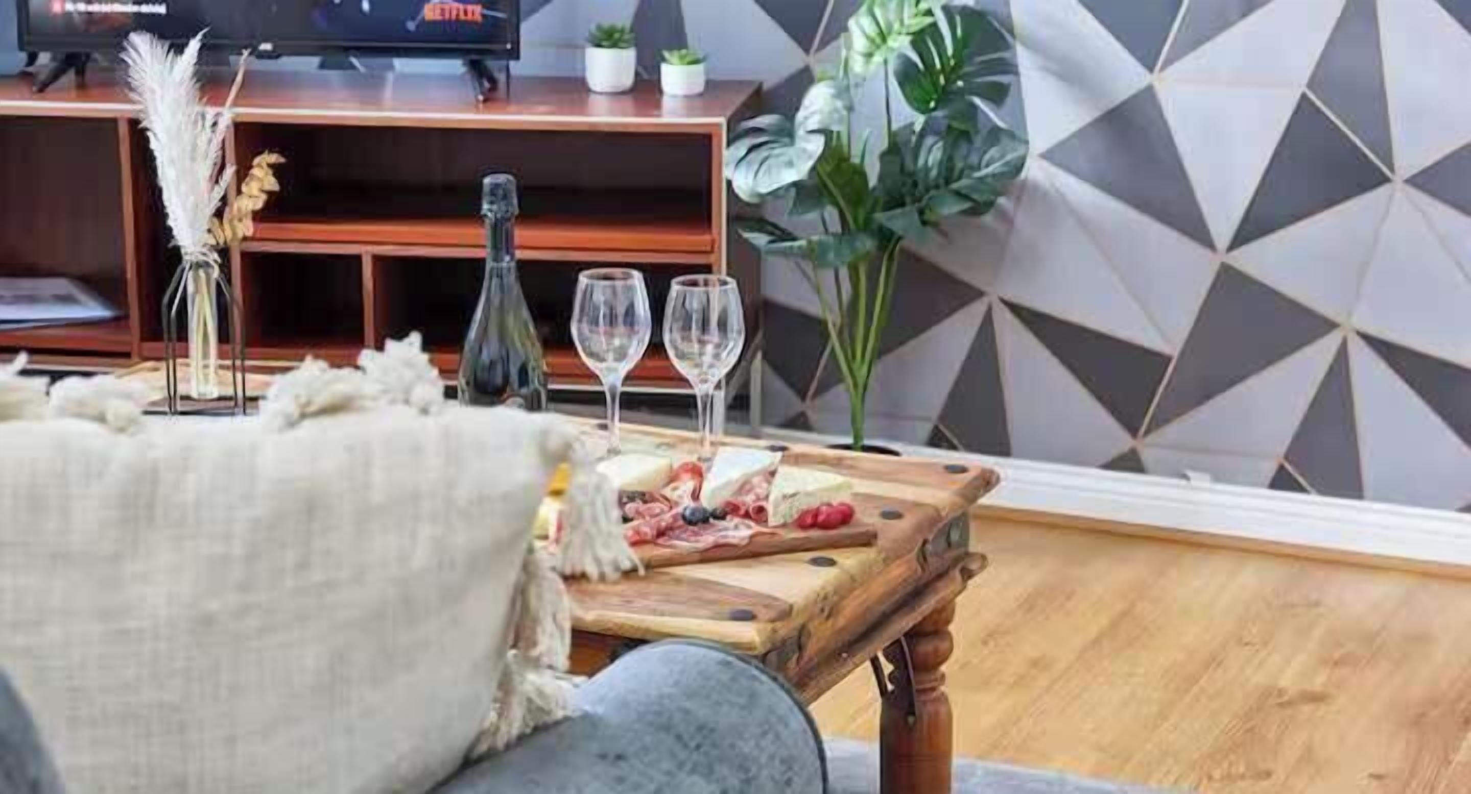Un salon chaleureux avec une table basse en bois, un téléviseur et une plante.