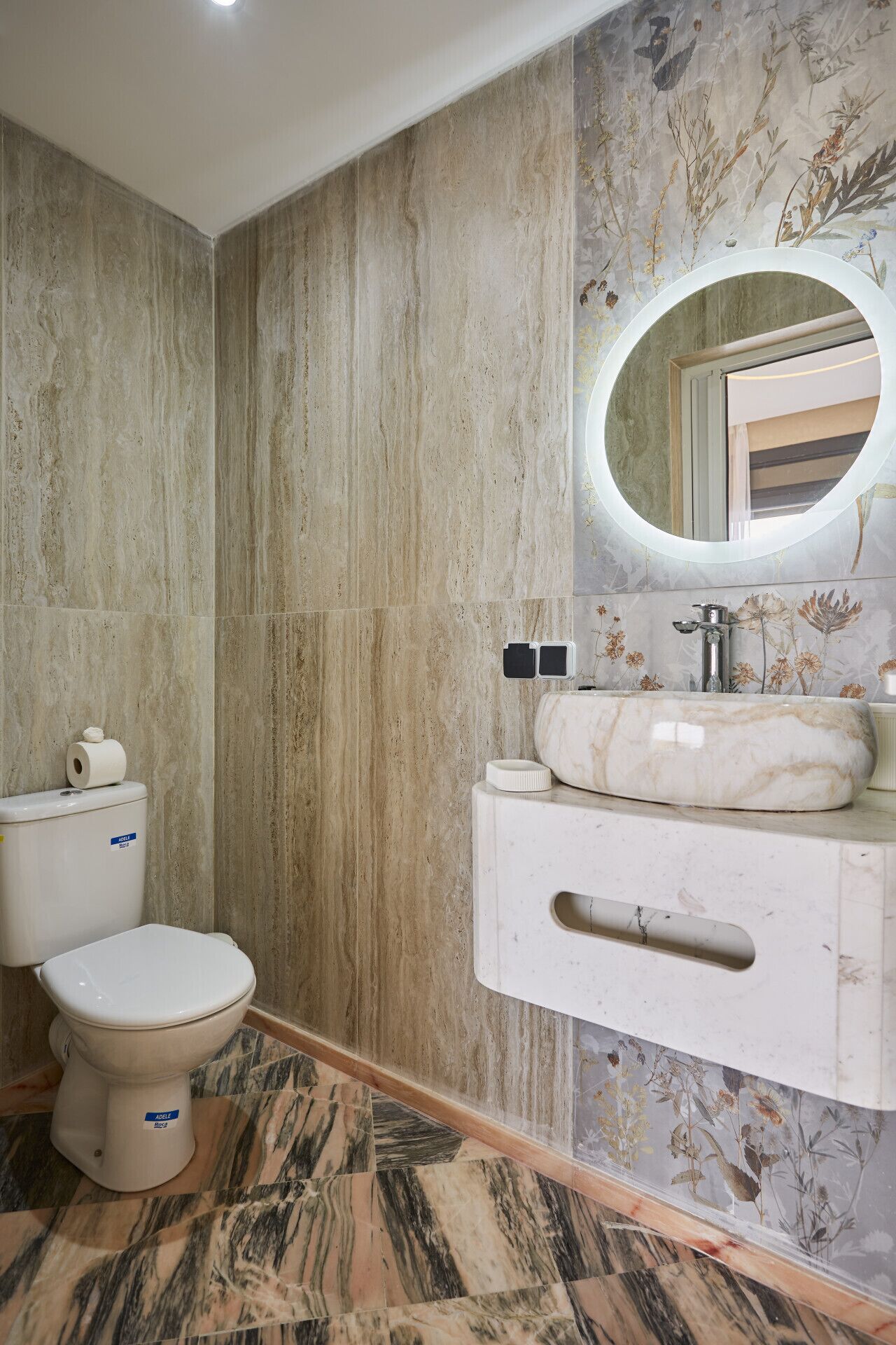 A bathroom with a toilet, sink, and mirror.