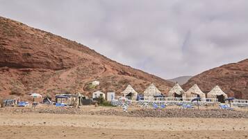 Un paysage désertique avec des tentes et des chaises de plage.